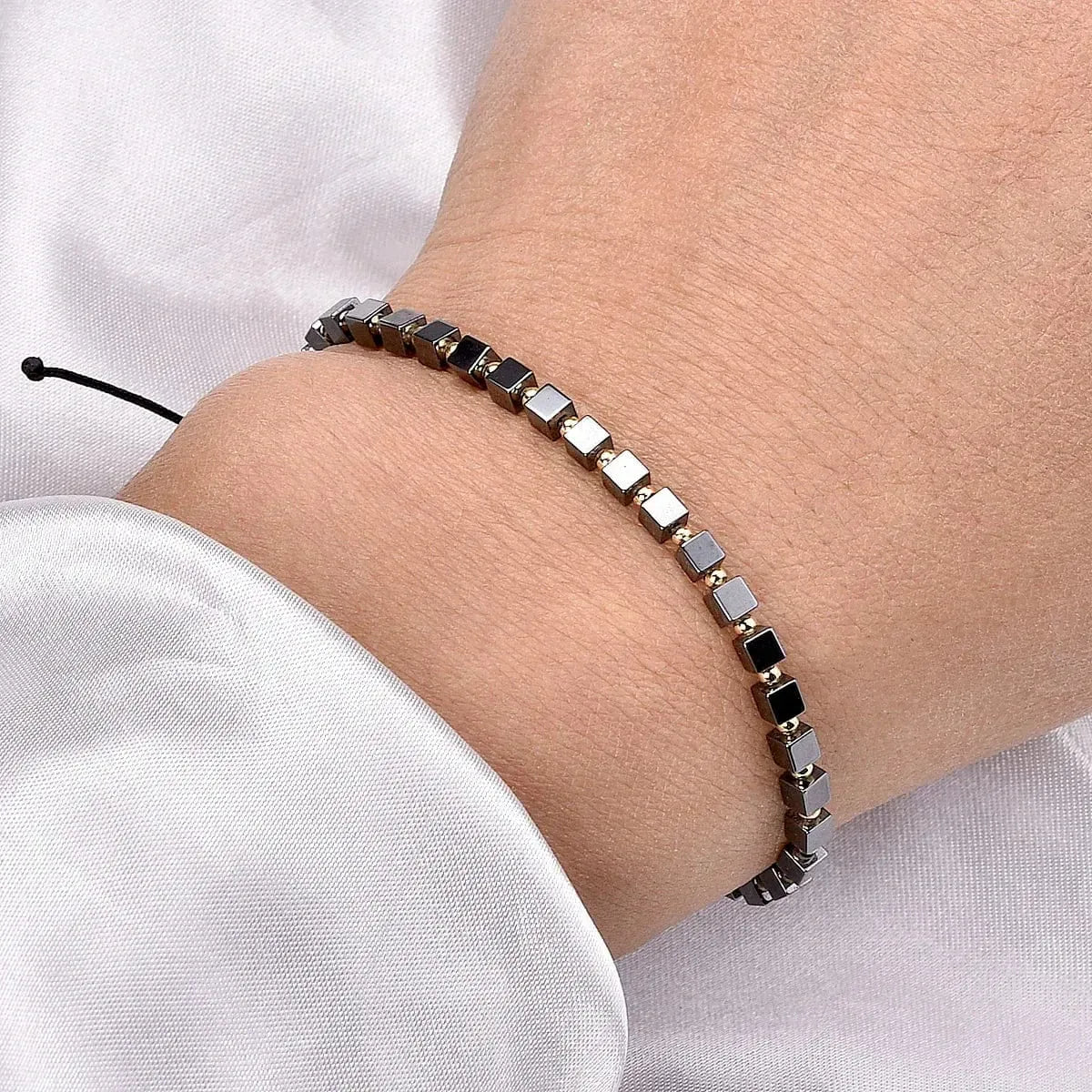 Bracelet with black and silver beads on a wrist against a white background