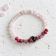 Rose quartz stretch bracelet with pale pink rose quartz rounds and handblown glass rondelles around a dark gold-flecked glass focal