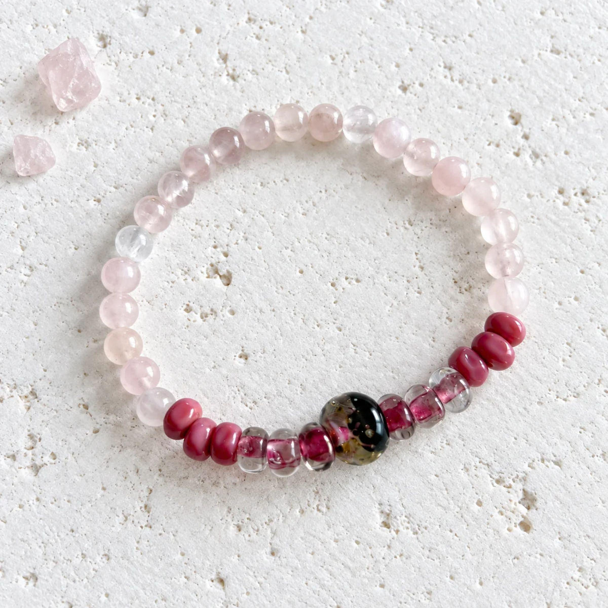 Rose quartz stretch bracelet with pale pink rose quartz rounds and handblown glass rondelles around a dark gold-flecked glass focal