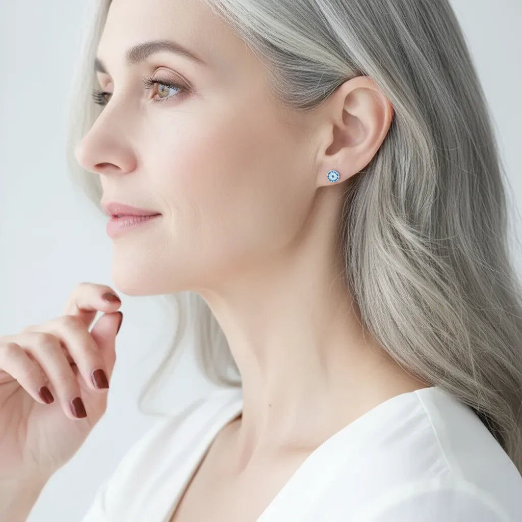 Woman wearing a blue and silver earring on a light background