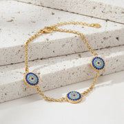 Gold bracelet with blue and gold circular charms on a white background, branded 'Lokaer'.