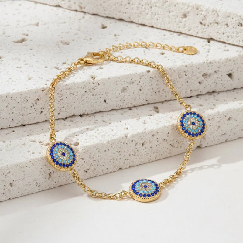 Gold bracelet with blue and gold circular charms on a white background, branded 'Lokaer'.