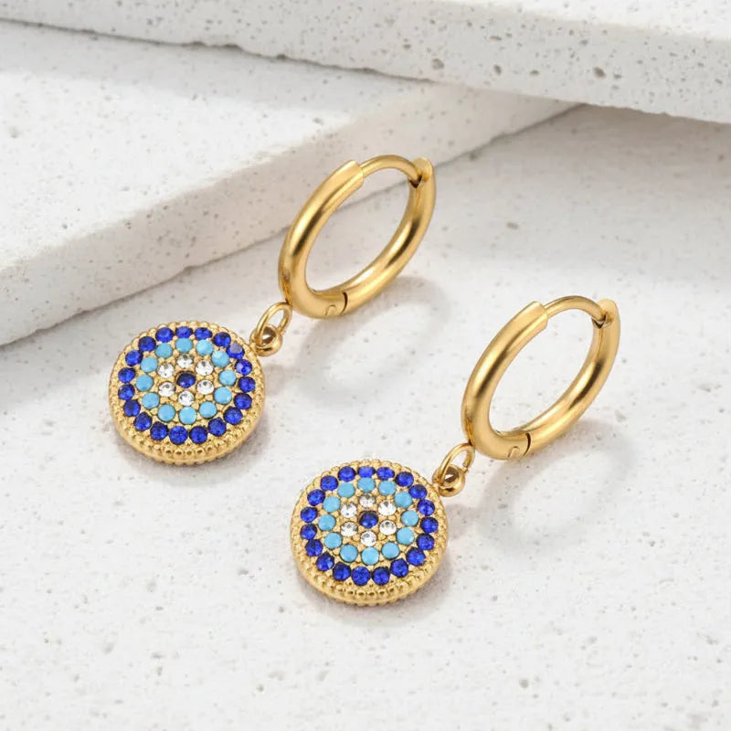 Gold hoop earrings with blue and turquoise gemstone drops on a white background