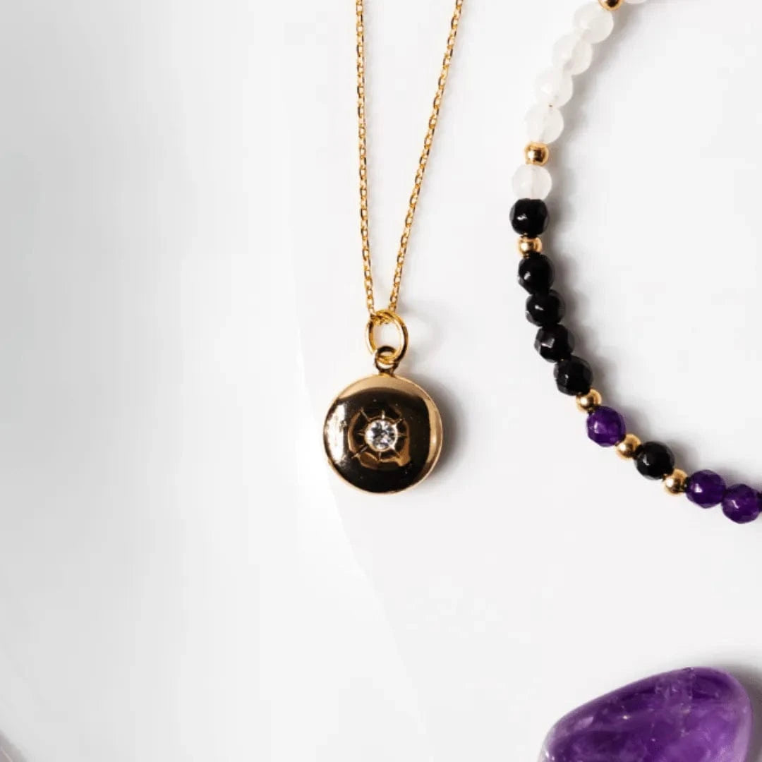 Gold necklace with a pendant and beaded necklace on a white background