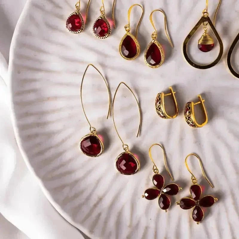 birthstone jewelry in ruby and garnet showing earrings on a place life style photo