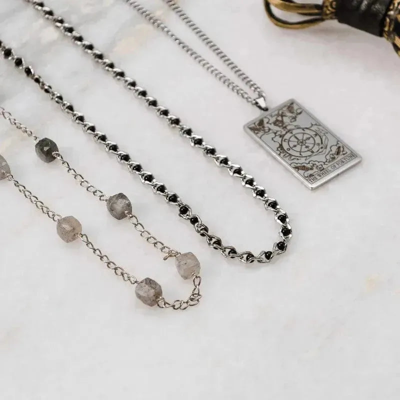 Necklace with gemstones and a decorative pendant on a marble surface