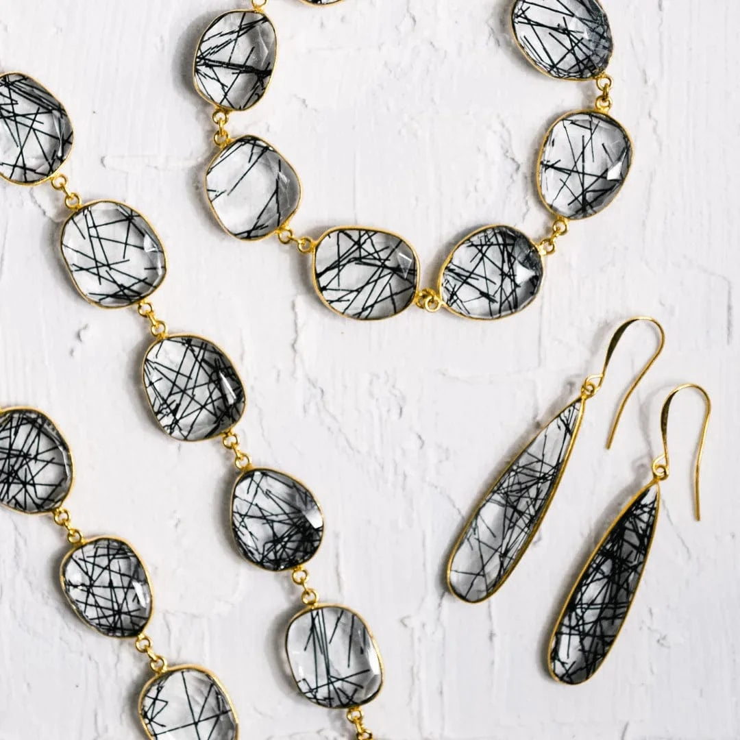 Jewelry set with necklace and earrings on a textured white surface