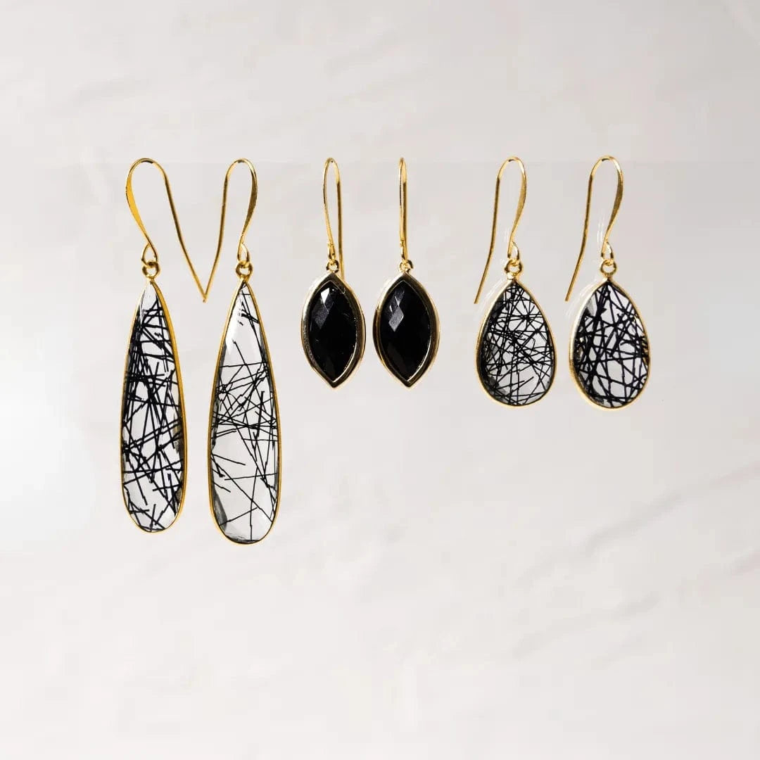 Set of black and gold teardrop earrings on a white background