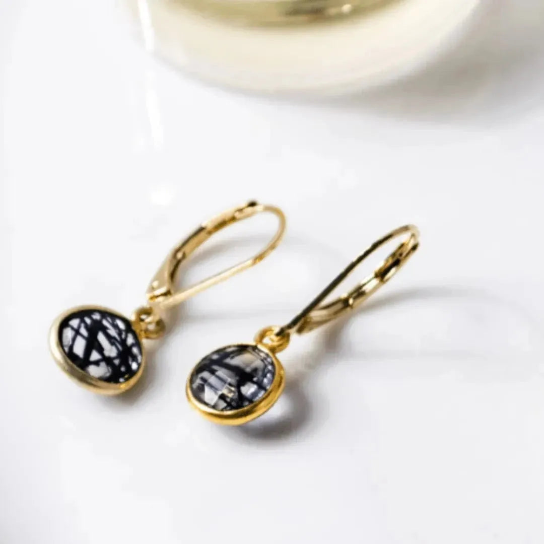 Gold earrings with black gemstones on a white background