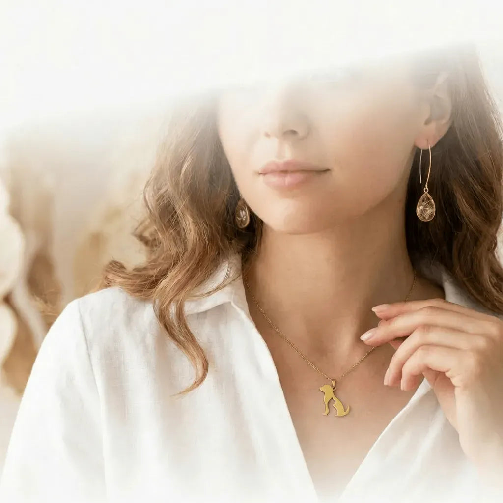 Woman wearing gold jewelry including a necklace and earrings with a blurred background