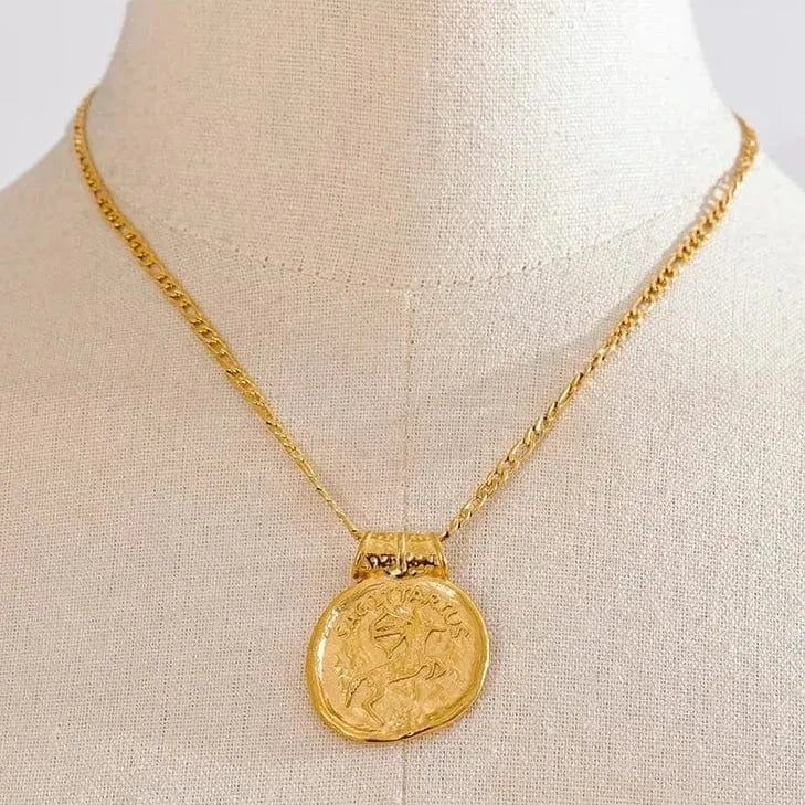 Gold necklace with a round pendant on a mannequin bust.