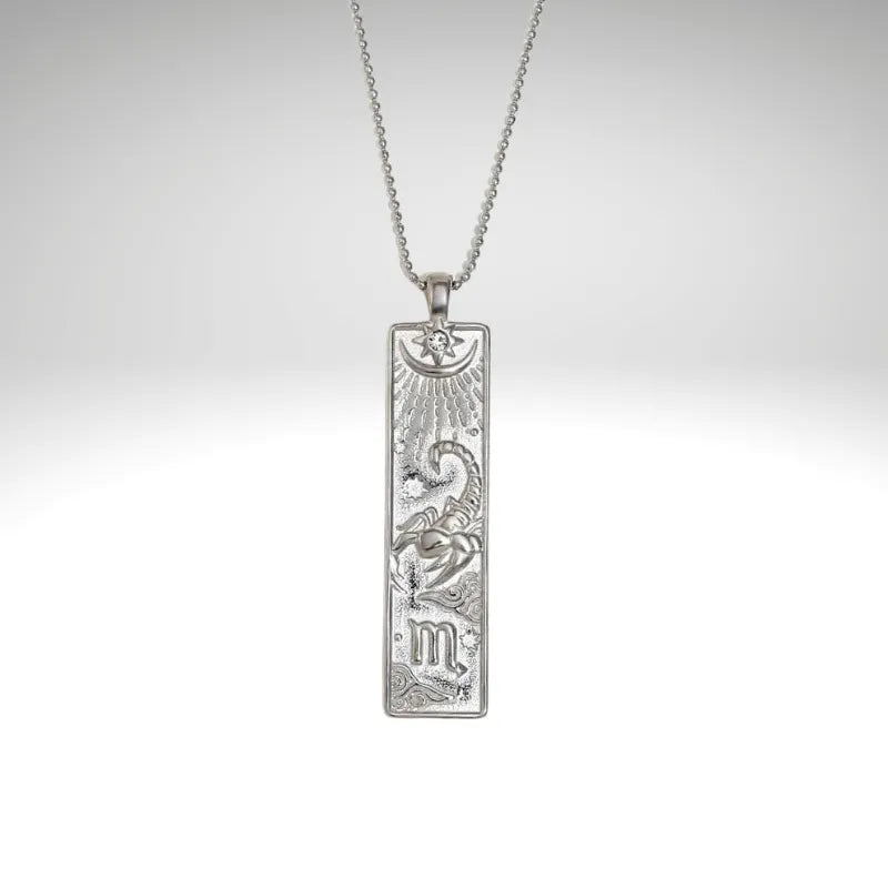 Silver pendant necklace with intricate design on a light gray background