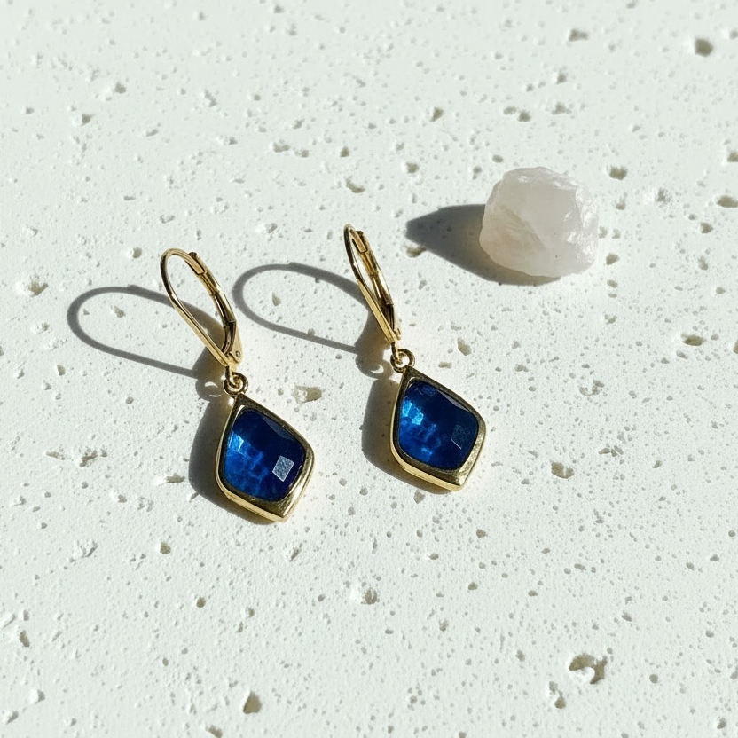 Gold Selene drop earrings with capri blue faceted glass on textured stone