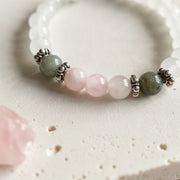 Selenite stretch bracelet close-up showing white selenite beads with labradorite and rose quartz at the front