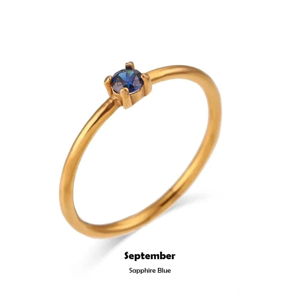 Gold ring with a sapphire stone on a white background