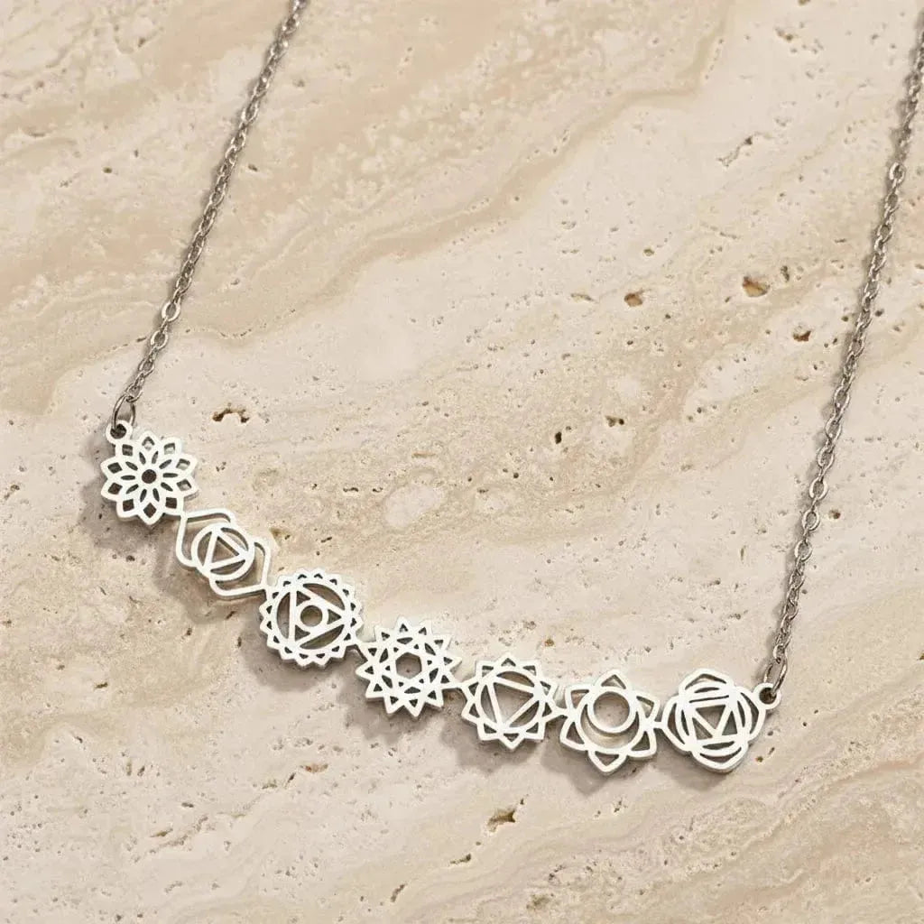 Silver necklace with floral designs on a black background