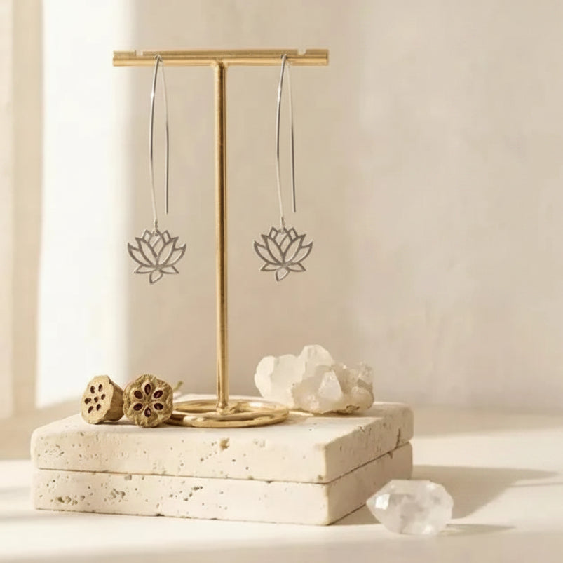Gold lotus flower earrings on a stand — spiritual symbol jewelry for growth and renewal