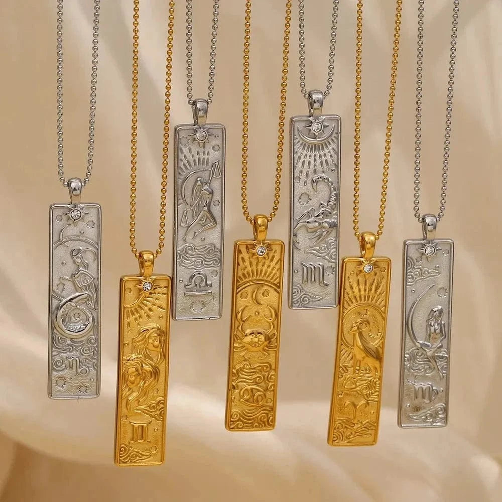 Set of gold and silver necklaces with zodiac pendant designs on a beige background