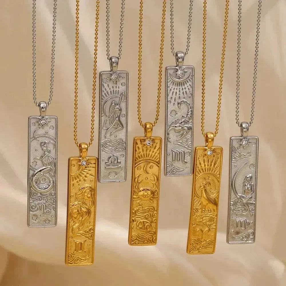 Set of gold and silver necklaces with zodiac pendant designs on a beige background