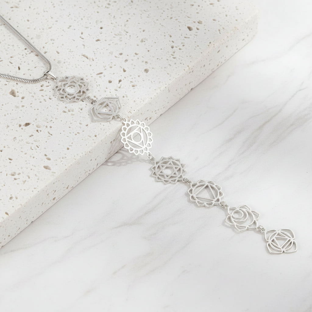 Silver necklace with intricate design on a black background
