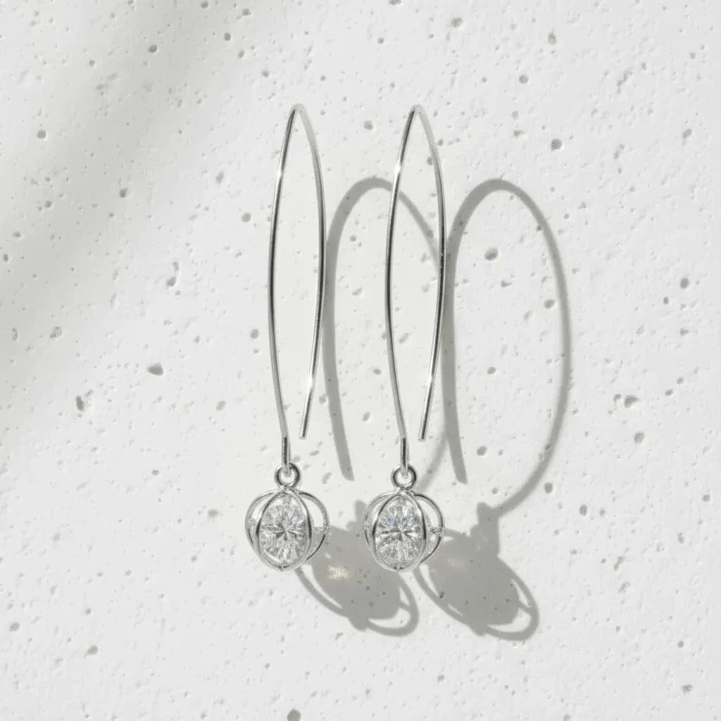 Silver earrings with circular designs on a light gray background