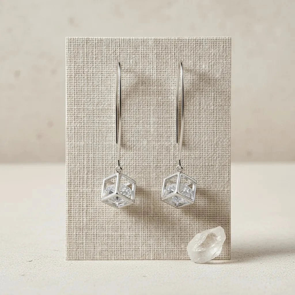 Crystal earrings on a textured card with a beige background