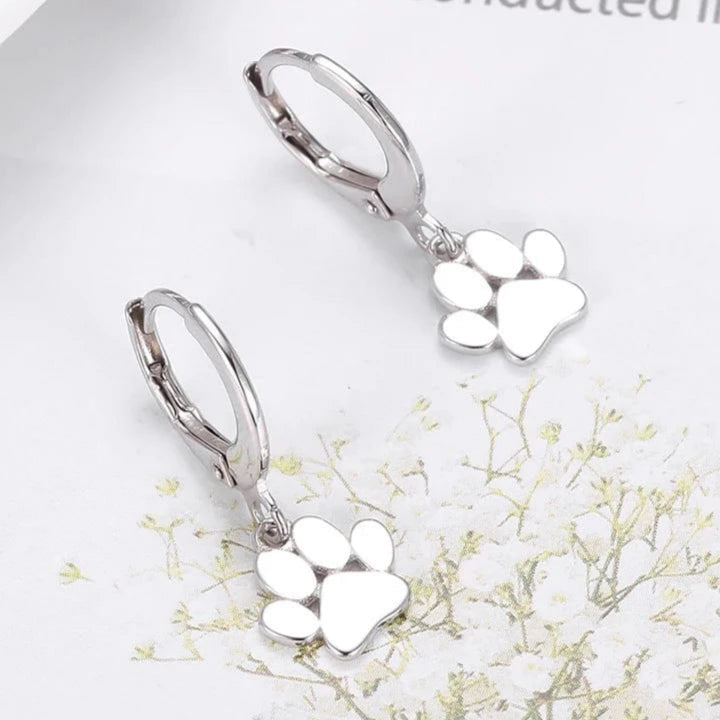 Silver paw print earrings on a white background with text