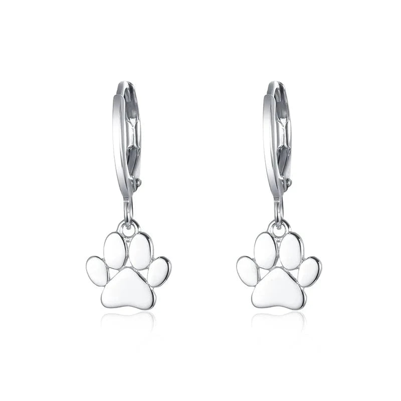 Silver paw print earrings on a white background