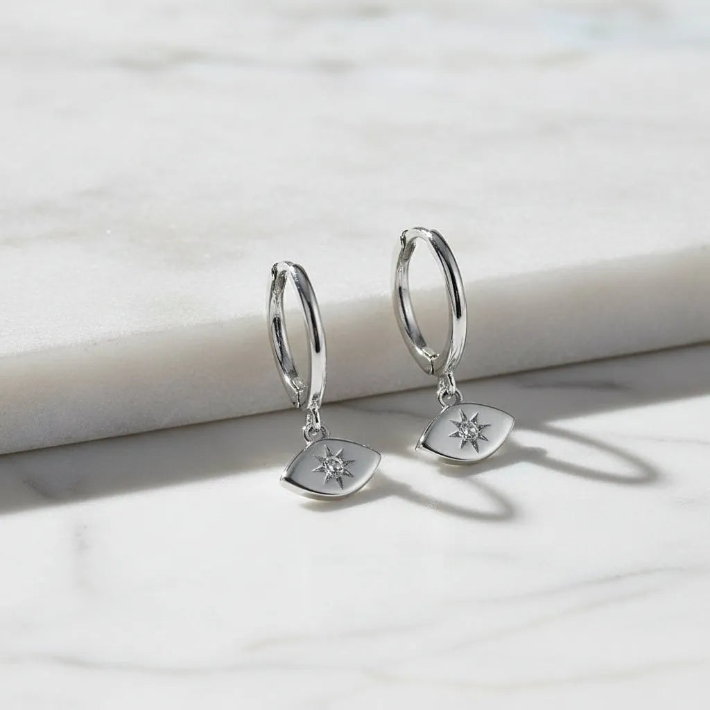 Silver earrings with eye-shaped pendants on a white background 