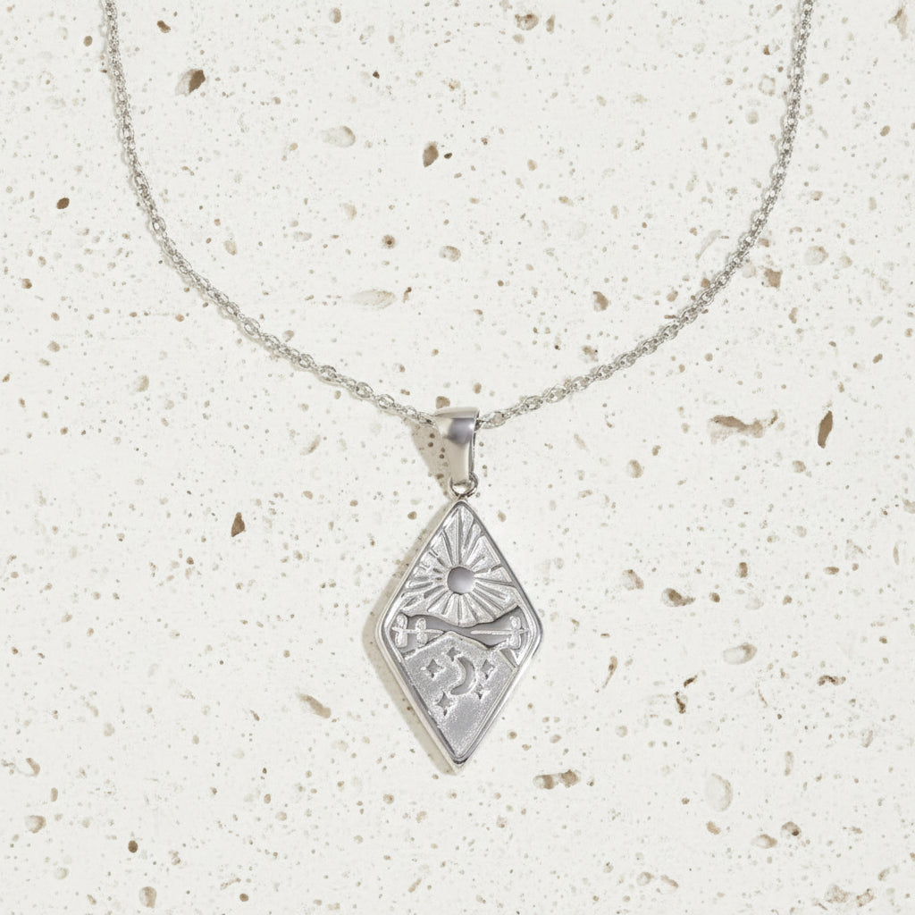 Silver necklace with a diamond-shaped pendant on a white background 
