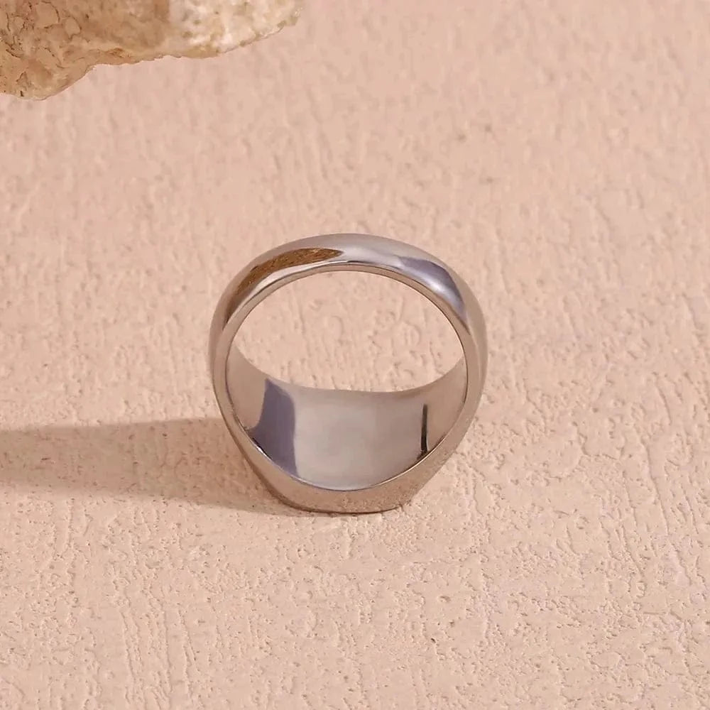 Silver ring on a textured beige surface