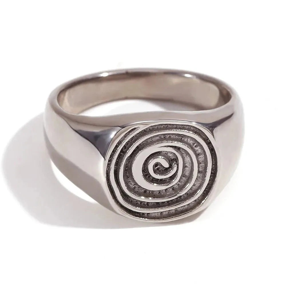 Silver ring with a spiral design on a white background