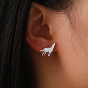 Silver wolf stud earring worn on the ear — mini spirit animal jewelry