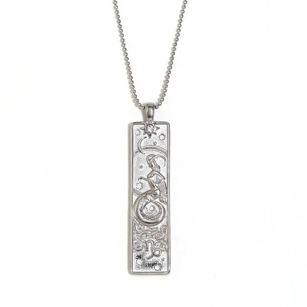 Silver pendant necklace with intricate design on a white background