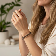 Woman wearing a smoky quartz root chakra bracelet — root chakra jewelry for grounding