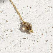 Gold necklace with a pendant on a white background