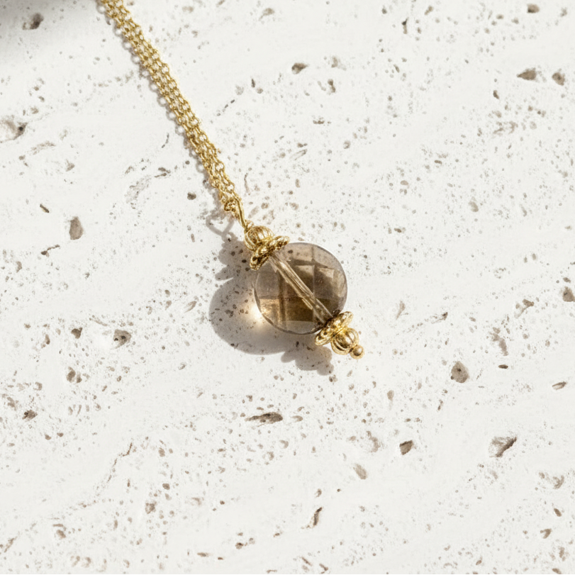 Gold necklace with a pendant on a white background