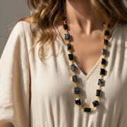 Woman wearing a long gold snowflake obsidian chain necklace — crystal necklace for grounding