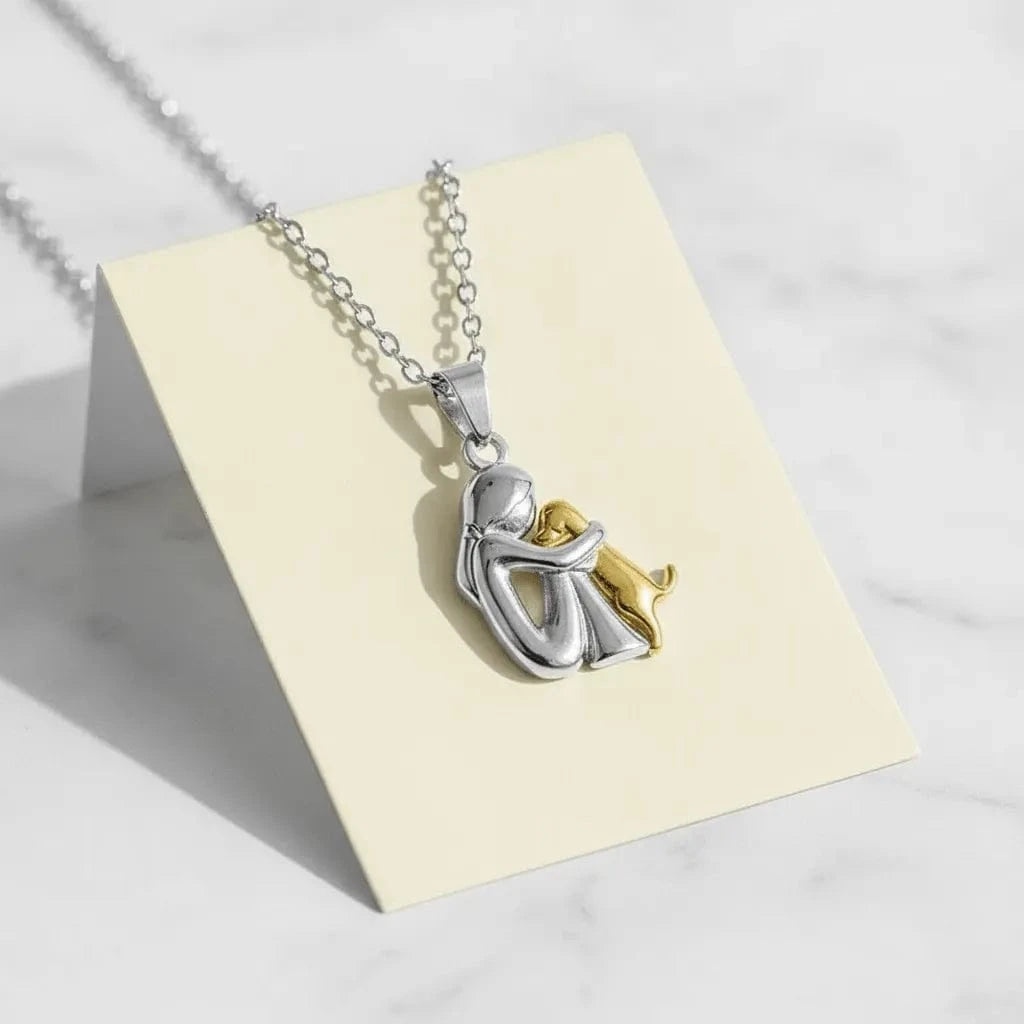 Silver and gold pendant necklace on a white card with a white background