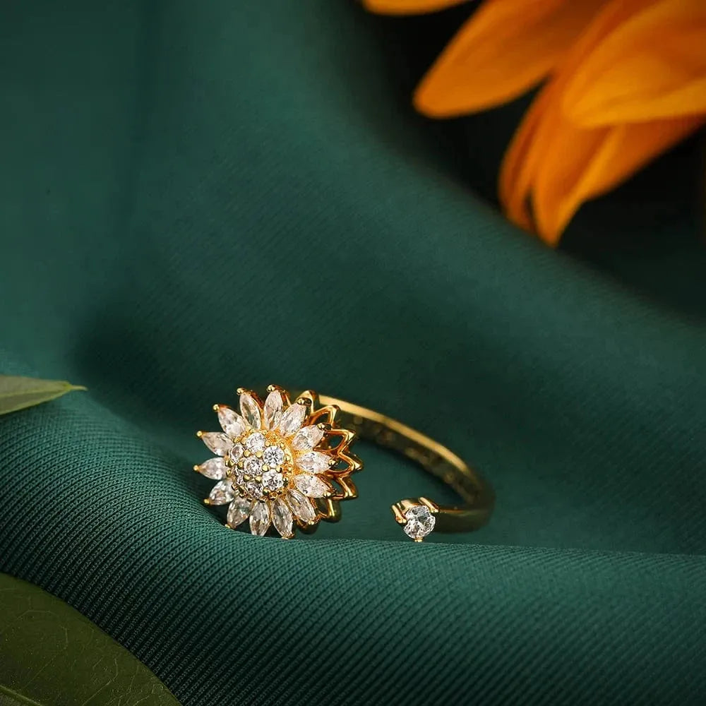 Gold ring with diamond accents on a green fabric background