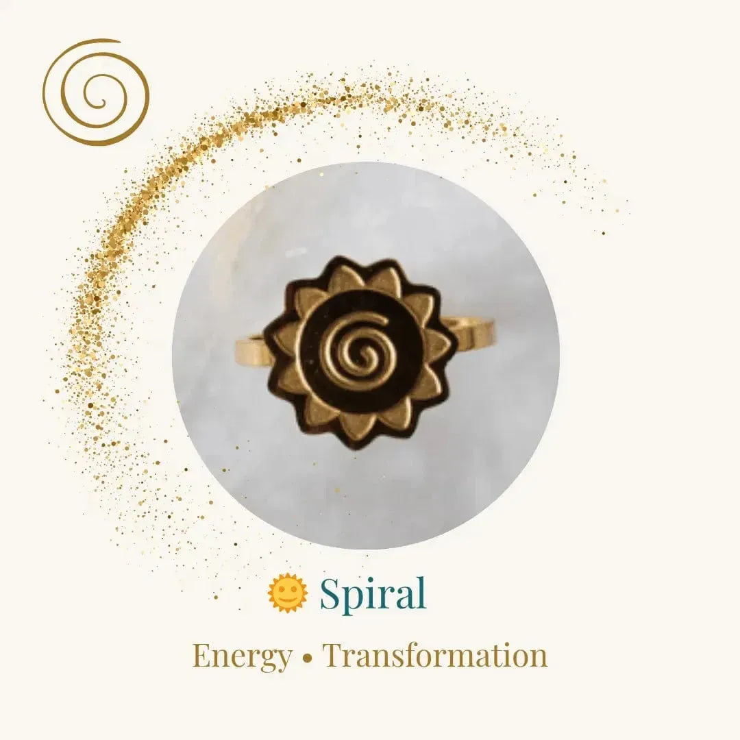 Gold ring with spiral design on a white stone, surrounded by gold dust, on a light beige background.