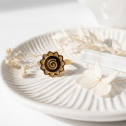 Spiral ring on a white shell with text about transformation journey and material.