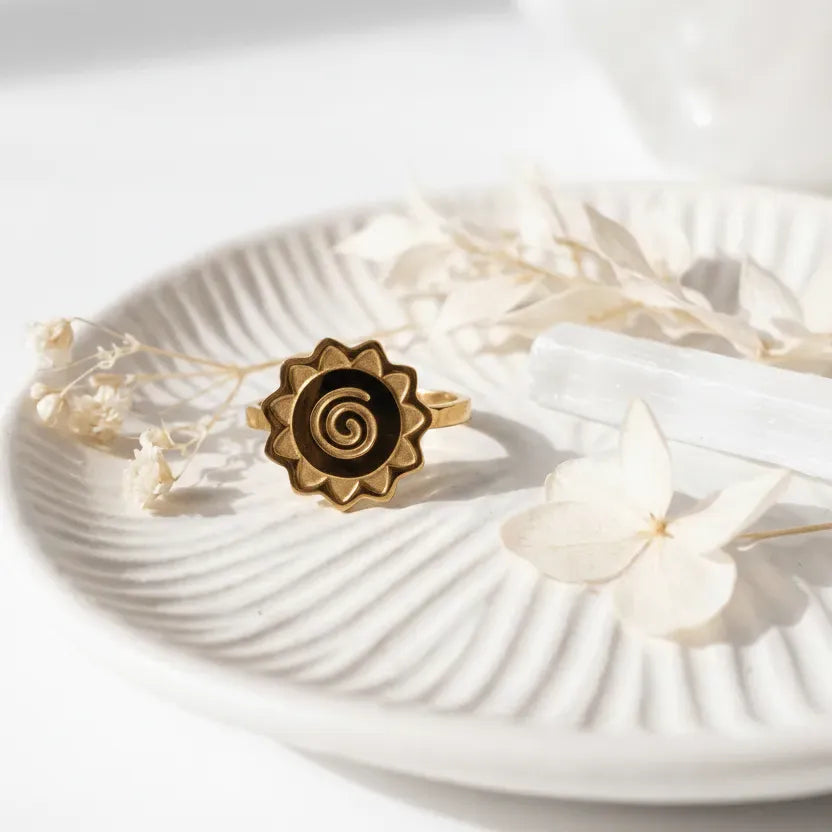 Spiral ring on a white shell with text about transformation journey and material.