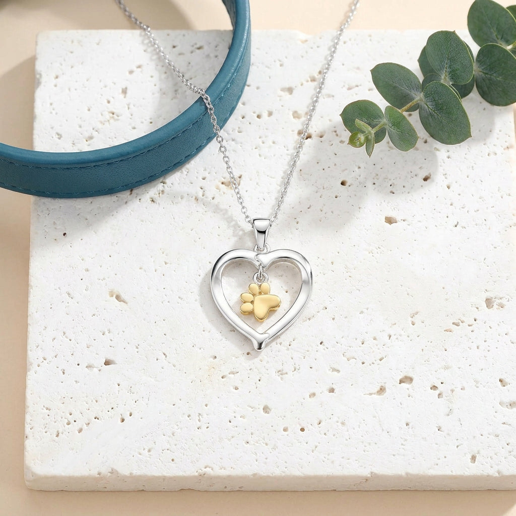 Silver heart pendant with gold paw print — keepsake necklace for love and rescue