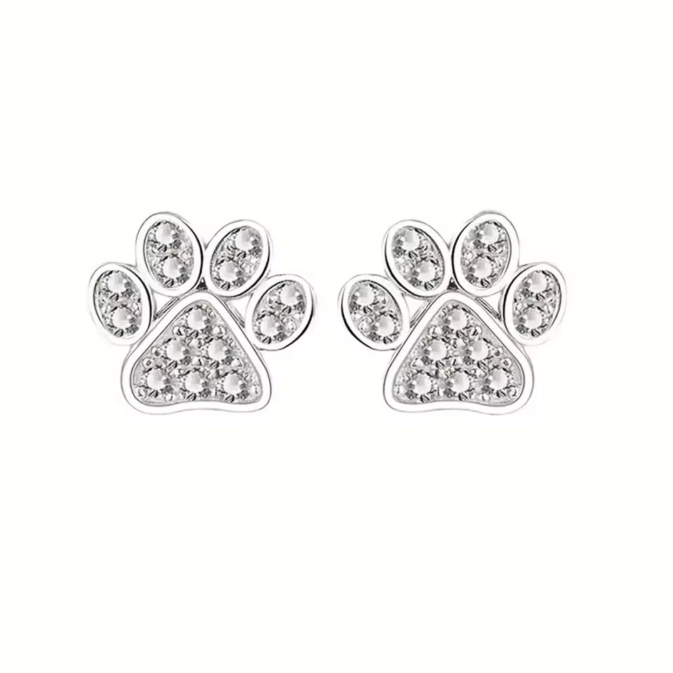 crystal stud earrings with engraved paw designs on a white background