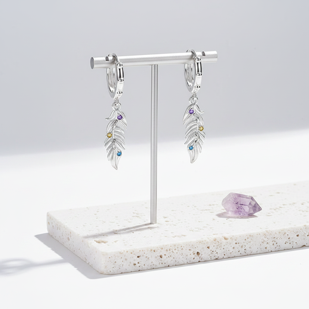 Pair of sterling silver feather earrings hanging side by side