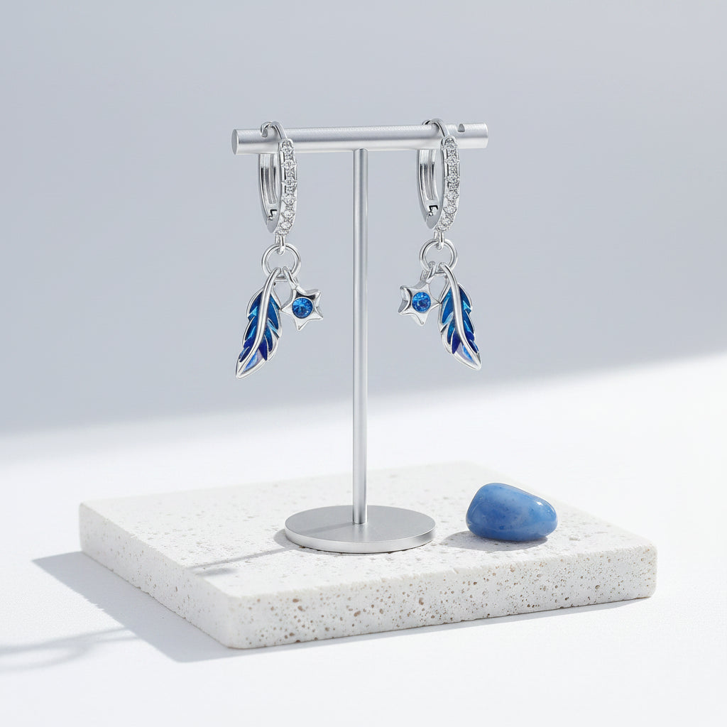 Sterling silver feather hoop earrings hanging, showing the full drop