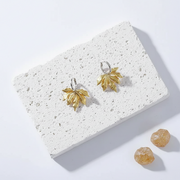 Sterling silver leaf drop earrings with gold plating, shown against a plain background
