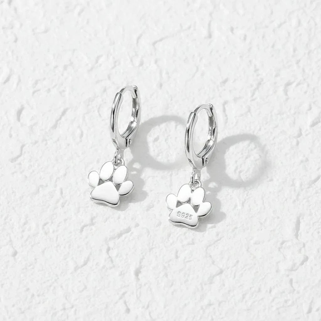 Silver paw print earrings on a white background with text