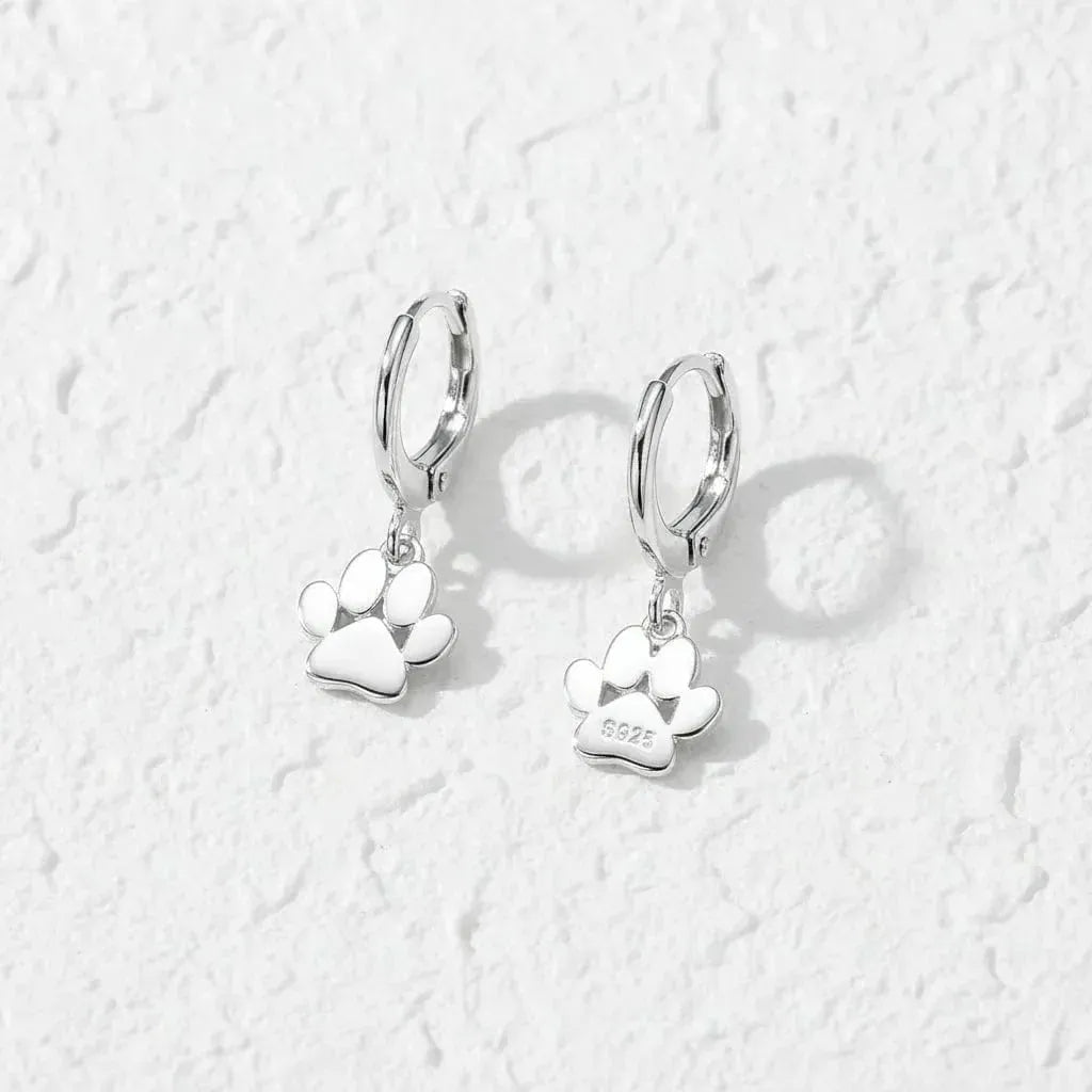 Silver paw print earrings on a white background with text